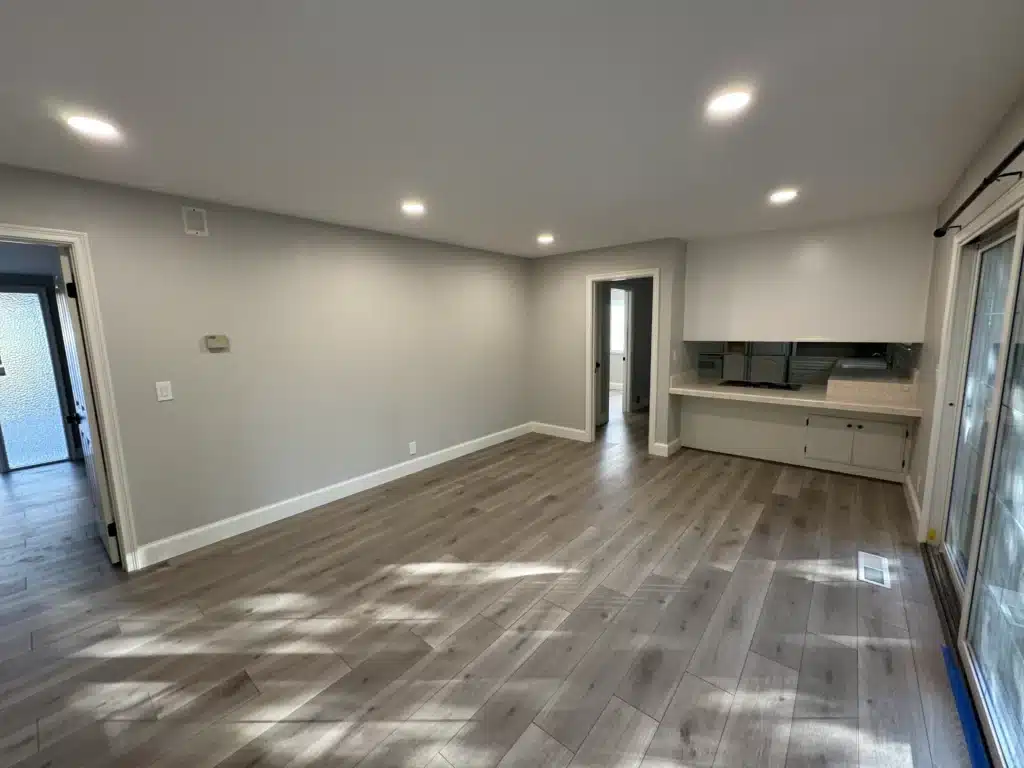Modern living area with wood-look flooring, recessed lighting, and neutral color palette in North Hollywood remodel.
