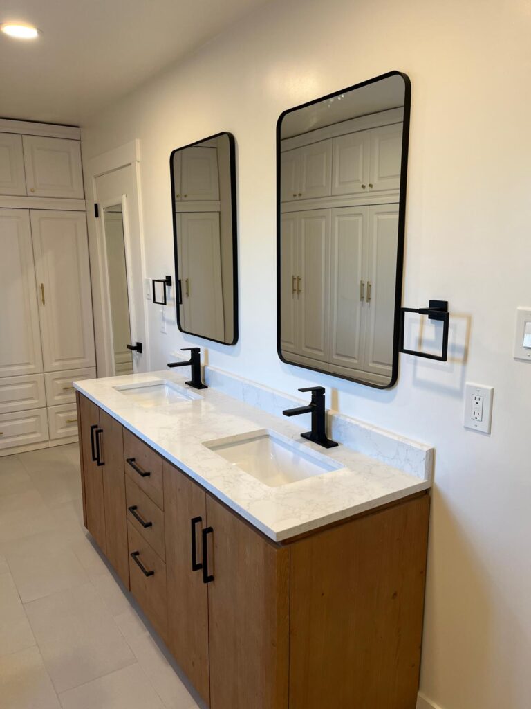 Modern bathroom remodel by Denali Builders & Design featuring a double vanity with wood cabinetry,