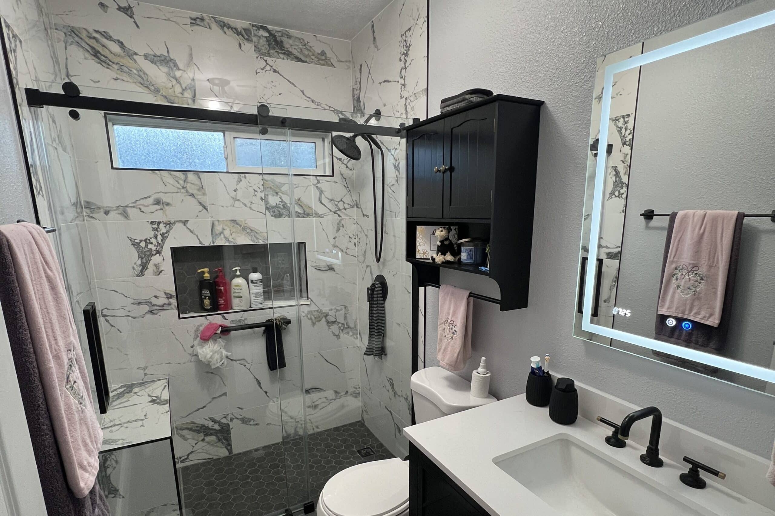 Contemporary bathroom shower with marble wall surfaces and a bright, refined interior design