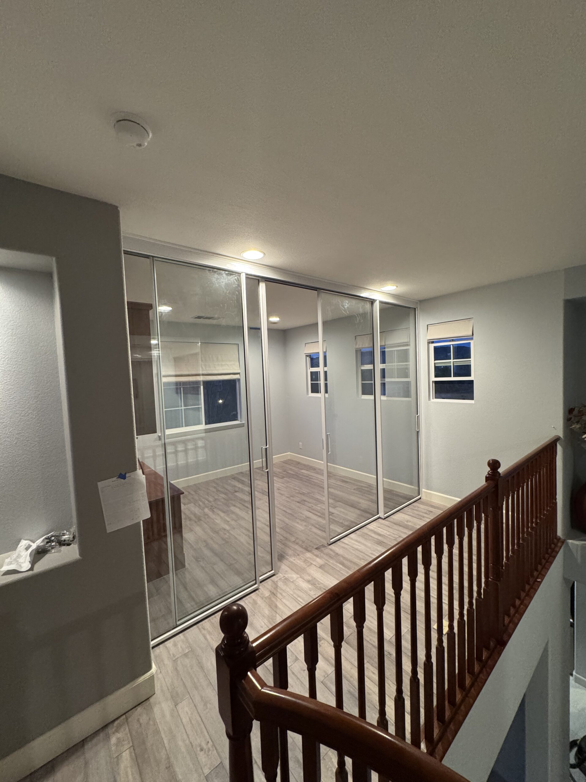 Newly converted upstairs loft office featuring floor-to-ceiling glass walls and sliding doors, showcasing Denali Builders