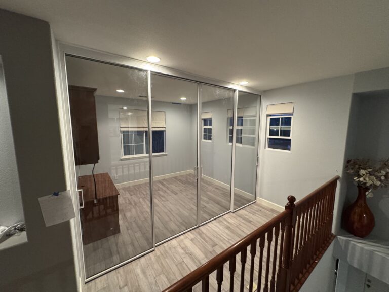 Upstairs loft converted into a home office, featuring floor-to-ceiling glass walls, modern lighting