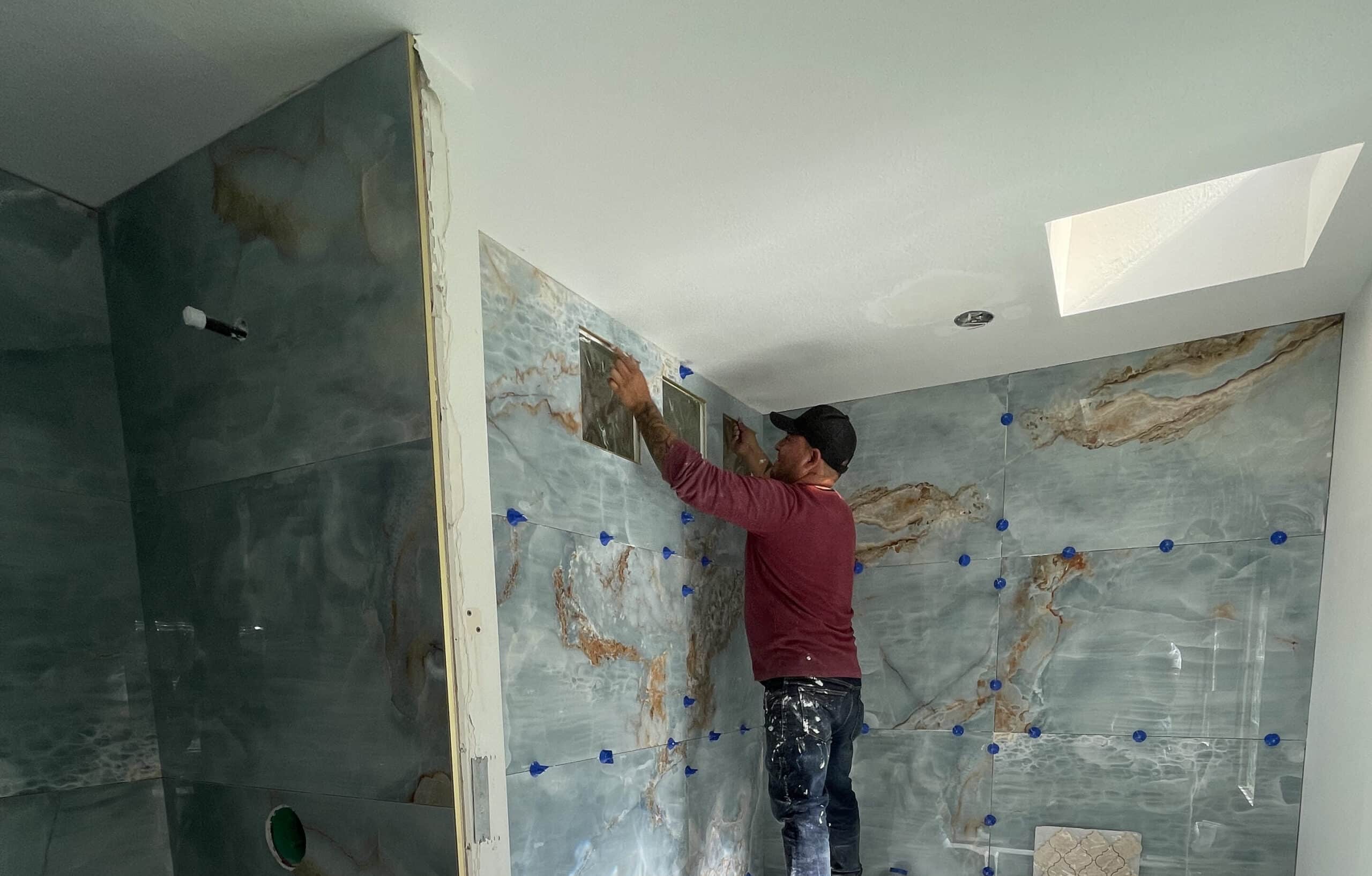 Worker setting up new marble tiles in a bathroom