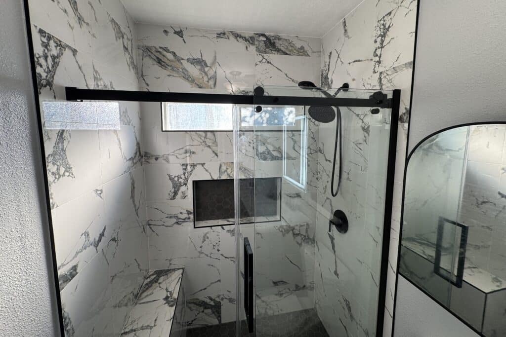 Modern bathroom shower with elegant marble wall detailing and a clean, contemporary design
