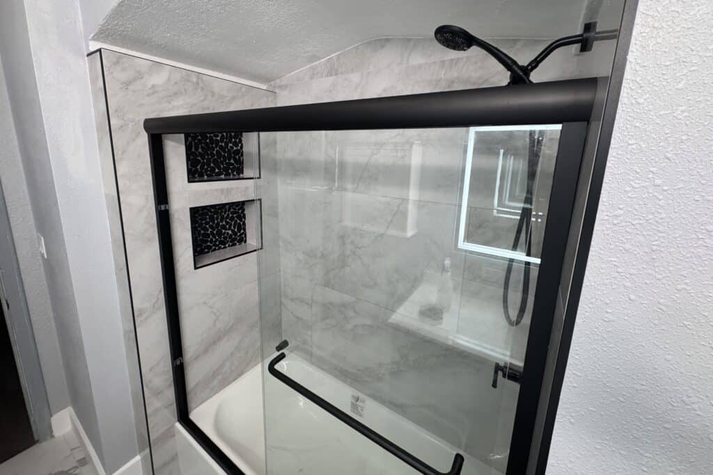 Spacious shower area featuring marble walls and a simple, modern bathroom style