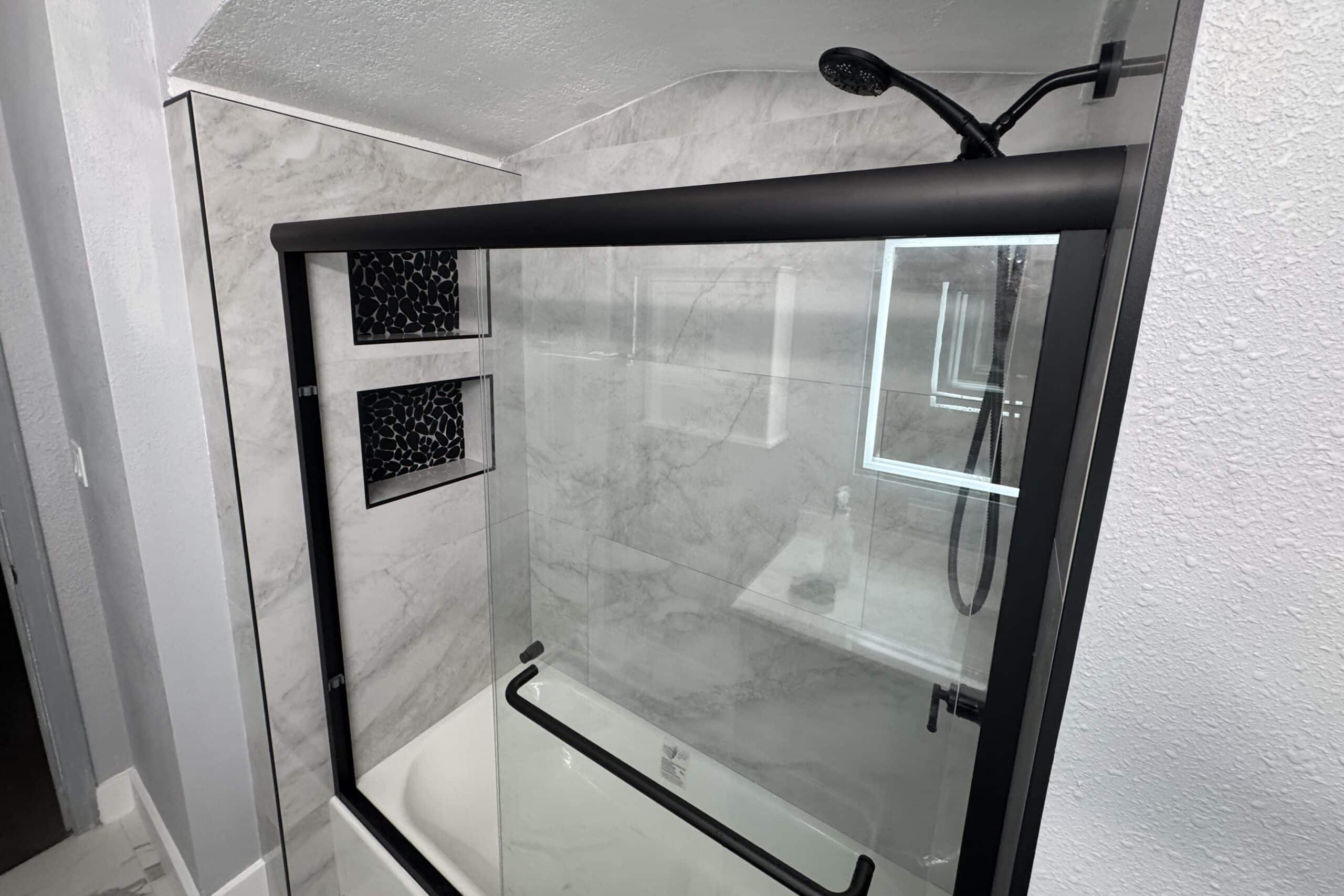 Spacious shower area featuring marble walls and a simple, modern bathroom style